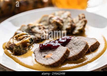 Filetti di manzo dalla bistecca con salsa tradizionale ceca, gnocchi di Karlovy Vary con mirtilli rossi e buona birra ceca. Foto Stock