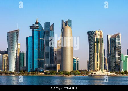 Lo skyline (Torre di Doha, Torre al Baidda, Torre Tornado e Torre al Mirqab) lungo la Corniche di Doha, Qatar Foto Stock