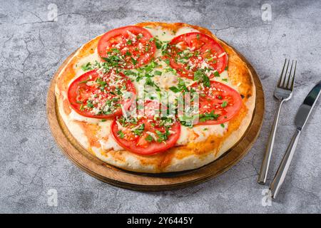 Pizza Margherita napoletana con pomodori, mozzarella, basilico e olive su tavola di pietra Foto Stock