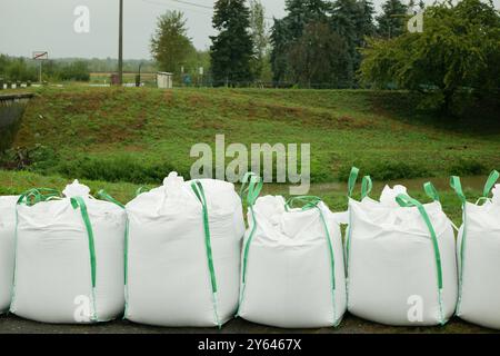 Barriera protezione da sacchi di sabbia barriera d'acqua di fiume di inondazione muro allagato pericolo di pioggia case di costruzione villaggi infrastrutture di automobili scomode che piovono l'Europa Foto Stock