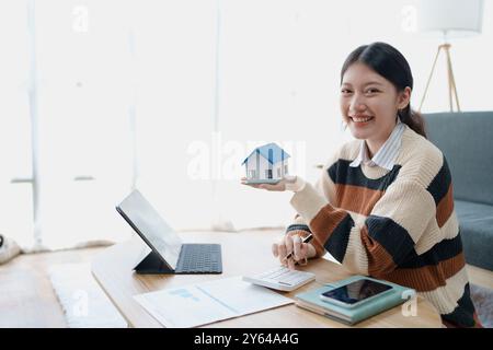 woman elabora un piano di risparmio finanziario incentrato sulla garanzia di un prestito residenziale, gestendo con attenzione il proprio budget per raggiungere la proprietà familiare e la fin a lungo termine Foto Stock