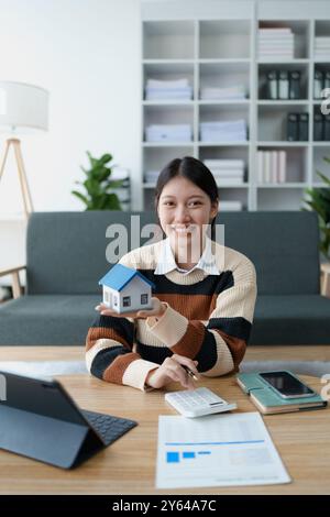 woman elabora un piano di risparmio finanziario incentrato sulla garanzia di un prestito residenziale, gestendo con attenzione il proprio budget per raggiungere la proprietà familiare e la fin a lungo termine Foto Stock