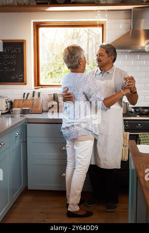 Balla, cucina e coppia senior in cucina per legare, amare relazioni e romanticismo in casa. Pensione, matrimonio e uomo maturo e.. Foto Stock