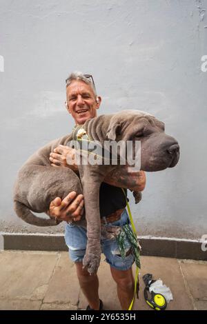 Inghilterra, Kent, Folkestone, Ritratto di uomo che tiene in mano un cane da compagnia di grandi dimensioni Foto Stock