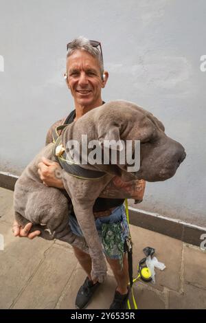 Inghilterra, Kent, Folkestone, Ritratto di uomo che tiene in mano un cane da compagnia di grandi dimensioni Foto Stock