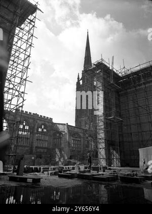 Guardando attraverso l'ingresso della nuova Cattedrale di Coventry , si può vedere il guscio della guerra che ha sbigottito la Cattedrale di San Michele . Sarà mantenuto come simbolo del coraggio di Coventry durante la guerra , e sarà costruito un portico di collegamento tra questa e la nuova cattedrale . Basil Spence l' ha progettata e sarà consacrata nel 1962 , anche se i servizi sono già svolti nella Cappella della Croce nella Cripta . L'edificio sara' alto circa 100 piedi, sormontato da una singola guglia a cecchino. La navata è lunga 270 piedi e larga 80 piedi. La cripta è lunga 86 metri e varia tra i 30 e i 60 metri Foto Stock