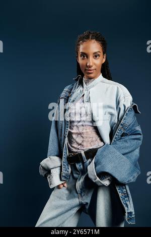 Una giovane donna alla moda indossa elegantemente un abbigliamento chic in denim, trasudando fiducia e stile. Foto Stock