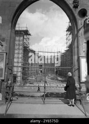 Guardando attraverso l'arco della nuova Cattedrale di Coventry , si può vedere la conchiglia della guerra che ha abbellito la Cattedrale di San Michele . Sarà mantenuto come simbolo del coraggio di Coventry durante la guerra , e sarà costruito un portico di collegamento tra questa e la nuova cattedrale . Basil Spence l' ha progettata e sarà consacrata nel 1962 , anche se i servizi sono già svolti nella Cappella della Croce nella Cripta . L'edificio sara' alto circa 100 piedi, sormontato da una singola guglia a cecchino. La navata è lunga 270 piedi e larga 80 piedi. La cripta è lunga 86 metri e varia tra 30 e 60 metri Foto Stock