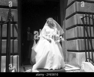 In un abito di crinoline di tulle bianco Lady Caroline Montagu Douglas Scott lasciò la sua casa londinese a Grosvenor Square per il suo matrimonio all' Abbazia di Westminster con il signor Ian Hedworth Gilmour , figlio di Sir John Gilmour . Lady Caroline , figlia ventitreenne del Duca e della Duchessa di Buccleuch , è la quarta delle damigelle della Principessa Elisabetta a sposarsi . Visto qui sposa e sposo lasciare l'Abbazia di Westminster dopo la cerimonia. Il principe Riccardo di Gloucester era una pagina. 10 luglio 1951 Foto Stock