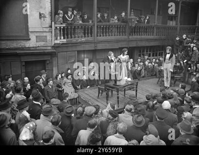 I Tabard Players hanno dato uno spettacolo all'aperto di scene di David Copperfield nel cortile del George Inn , Borough High Street , Londra . Un camion è stato utilizzato come palco . Il George Inn è menzionato in Dickens ' Little Dorrit '. Vista generale del primo atto in corso osservata da un pubblico nel cortile della locanda e sui vecchi balconi. A destra David Copperfield è interpretato da Richard James , un impiegato ventunenne di Sutton , Surrey . - 9 febbraio 1946 Foto Stock