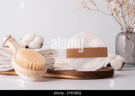 Tovaglioli di cotone riutilizzabili per il trucco, spazzola da bagno in legno e asciugamani morbidi. Concetto minimalista e sostenibile per un routi etico e senza sprechi di auto-cura Foto Stock