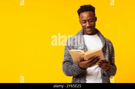 Romantico ragazzo africano lettura poesia in vecchio libro su giallo Foto Stock