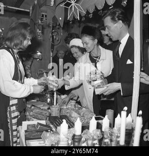 Apre il Tour finlandese - - la moglie dell' Ambasciatore finlandese a Londra , la signora Leo Tuominen ( seconda destra ) ispeziona alcuni dei beni esposti in una bancarella presso il bazar di natale finlandese , aperto dal marito , l' Ambasciatore presso la Chiesa dei Seamani finlandesi nel quartiere di Rotherhithe a Londra . Il bazar è in aiuto della chiesa. - 20 novembre 1963 Foto Stock