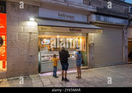 Famiglia con bambini / bambino / bambino, acquista gelato alla gelateria Bilisan, gelateria/gelateria popolare tra i turisti in un edificio/negozio a Nigerova Ulica, Spalato. Croazia. (138) Foto Stock