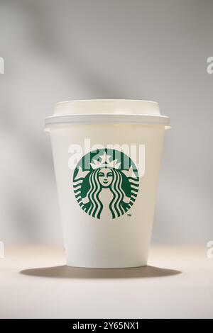 Bang Khae, Bangkok Thailandia - 24 settembre 2024: Una tazza da caffè Starbucks con il logo verde della sirena su uno sfondo semplice, che simboleggia il marchio globale Re Foto Stock