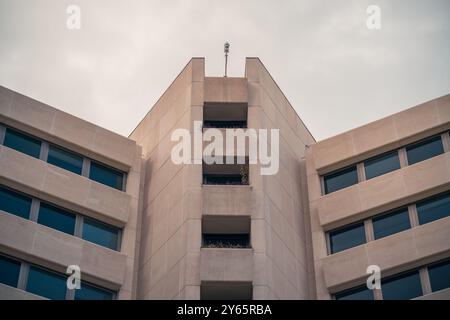 Vista simmetrica di un edificio moderno nell'AZCA, il quartiere finanziario di Madrid, che presenta un'architettura minimalista con cieli limpidi. Foto Stock