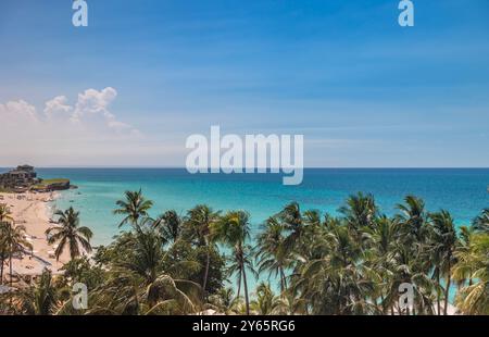 Cattura la spiaggia di Varadero a Cuba, caratterizzata da impressionanti acque turchesi, palme ondeggianti e una costa serena sotto un cielo limpido Foto Stock