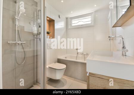 Un bagno contemporaneo con box doccia in vetro, piastrelle bianche e accenti in legno. Foto Stock