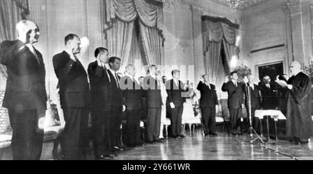 Dieci membri del gabinetto del presidente John Kennedy giurati dal giudice capo della Corte Suprema degli Stati Uniti Earl Warren (a destra): Da sinistra a destra: Segretario di Stato Rusk; Scretary del Tesoro Douglas Dillon; Robert McNamara (difesa); Robert Kennedy (procuratore generale); Edward Day (direttore generale delle poste); Stewart Udail (interni); Jacqueline e il presidente Kennedy; Adlai Stevenson (Nazioni Unite); Orville Freeman (Agricoltura); Arthur Hodges (Agricoltura); Luther (Luther). 22 gennaio 1961 Foto Stock