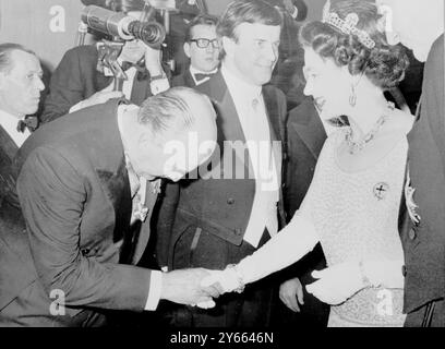 Sua Maestà la Regina Elisabetta II stringe la mano al dottor Eitel Monaco, presidente dell'industria cinematografica italiana, prima della rappresentazione del 1968 di Romeo e Giulietta. Al centro c'è il produttore italiano Franco Zeffirelli. 5 marzo 1968 Foto Stock