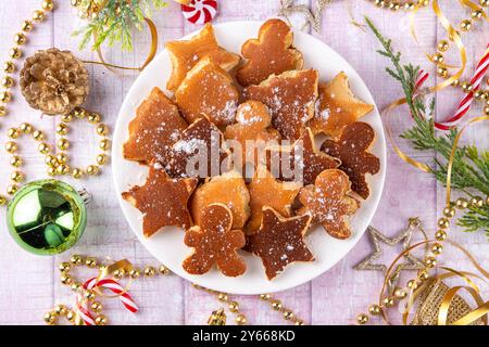 Idea creativa per la colazione di Natale, divertenti pancake natalizi sotto forma di gingerbread, albero di natale e stella, Foto Stock