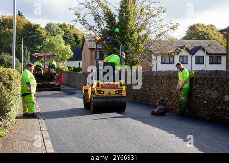 Operai che riparano superfici stradali, Rhu, Scozia, mostra strato di catrame e rullo stradale, Rhu, Scozia Foto Stock