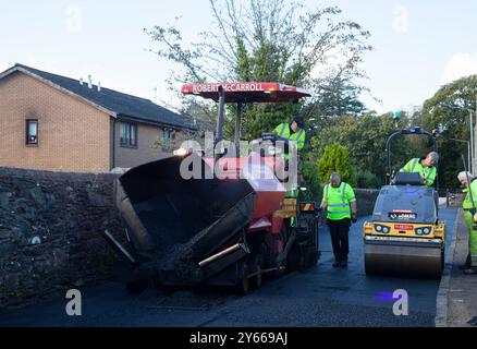 Operai che riparano superfici stradali, Rhu, Scozia, mostra strato di catrame e rullo stradale, Rhu, Scozia Foto Stock