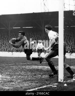 West Ham Utd contro il brillante portiere del Fulham Fulham, Macedo scaglia in aria e afferra la palla in mani sicure mentre salva da un attacco del West Ham nel pareggio di fa Cup a Upton Park. Langley, la schiena sinistra di Fulham, copre la linea della porta. Fulham ha vinto il 3-1 15 febbraio 1958 Foto Stock