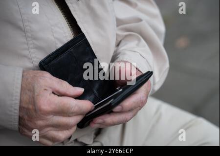 Berlino, Germania. 24 settembre 2024. Un pensionato tiene il portafoglio in mano. Crediti: Alicia Windzio/dpa/Alamy Live News Foto Stock