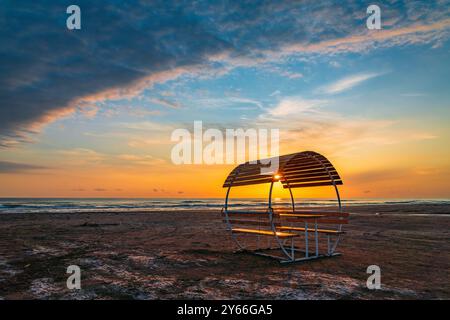 Un gazebo solitario e vuoto sulla spiaggia al di fuori della stagione turistica all'alba Foto Stock