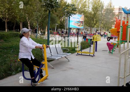 (240924) -- KASHGAR, 24 settembre 2024 (Xinhua) -- i residenti fanno esercizi mattutini in una piazza della comunità residenziale Donghu a Kashgar, nella regione autonoma di Xinjiang Uygur, nella Cina nord-occidentale, 22 settembre 2024. Negli ultimi anni, la comunità residenziale di Donghu a Kashgar ha esplorato attivamente nuovi modelli di gestione dei servizi per gruppi come anziani e bambini piccoli. Il centro cittadino della comunità è dotato di spazi che includono l'accademia di cultura tradizionale cinese, lo studio di danza, lo studio di musica, lo studio di pittura e calligrafia e la sala di consulenza psicologica. Il campo da badminton, Foto Stock