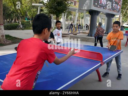 (240924) -- KASHGAR, 24 settembre 2024 (Xinhua) -- i bambini giocano a ping-pong nella comunità residenziale Donghu a Kashgar, nella regione autonoma di Xinjiang Uygur, nella Cina nord-occidentale, 22 settembre 2024. Negli ultimi anni, la comunità residenziale di Donghu a Kashgar ha esplorato attivamente nuovi modelli di gestione dei servizi per gruppi come anziani e bambini piccoli. Il centro cittadino della comunità è dotato di spazi che includono l'accademia di cultura tradizionale cinese, lo studio di danza, lo studio di musica, lo studio di pittura e calligrafia e la sala di consulenza psicologica. Il campo da badminton, ping pong co Foto Stock