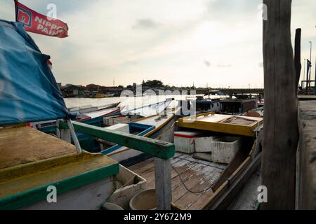 Le barche dei pescatori si appoggiano al molo del porto con una splendida vista del cielo serale Foto Stock