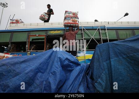 Kolkata, Bengala Occidentale, India. 24 settembre 2024. I laburisti caricano scatole di melagrane su un autobus passeggeri dopo che è arrivato da uno stato vicino in un terminal degli autobus a Kolkata, India, il 24 settembre 2024 (Credit Image: © Rupak De Chowdhuri/ZUMA Press Wire) SOLO PER USO EDITORIALE! Non per USO commerciale! Foto Stock