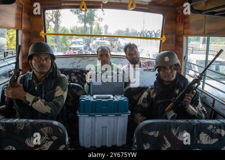 Funzionari del Kashmir che trasportano macchine per il voto elettronico (EVM) e Voter Verifiable Paper audit Trail (VVPAT), sorvegliati dal personale della Indian Border Security Force (BSF) dopo averle ritirate da un centro di distribuzione mentre partono per i rispettivi seggi elettorali prima della seconda fase delle elezioni dell'Assemblea legislativa del Jammu e del Kashmir nella periferia di Srinagar. Queste sono le prime elezioni locali in un decennio e anche per la prima volta da quando nuova Delhi ha spogliato lo status semi-autonomo della regione himalayana nel 2019 e l'ha portata sotto controllo diretto. Quasi n Foto Stock