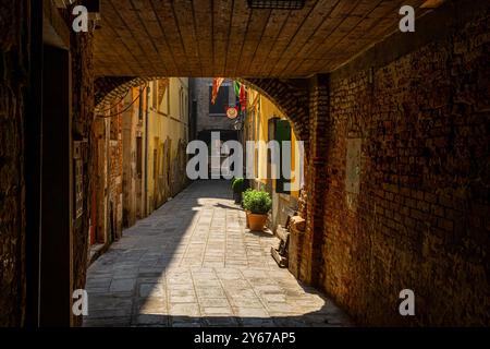 La luce del sole sul Sotoportego Coppo , un piccolo passaggio sotto un edificio nel sestiere di San Marco a Venezia Foto Stock