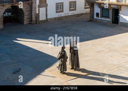 Monumento a los Mirandeses, sculture metalliche di un uomo e di una donna in tradizionale abito Mirandes, in piccola piazza, Miranda do Douro, Portogallo Foto Stock