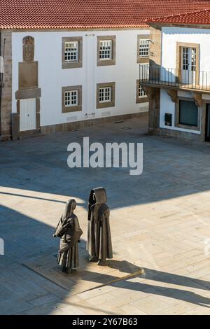 Monumento a los Mirandeses, sculture metalliche di un uomo e di una donna in tradizionale abito Mirandes, in piccola piazza, Miranda do Douro, Portogallo Foto Stock