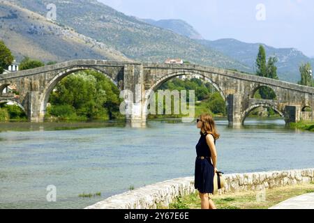 Una giovane donna gode della vista sul fiume Trebišnjica. Una donna turistica che cammina vicino al ponte Arsalanagić a Trebinje, Bosnia ed Erzegovina. Foto Stock