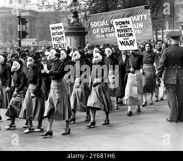 Guidati da dimostranti anti anti-guerra che indossano rappresentazioni di maschere antigas, migliaia di persone si sono riunite a trafalgar Square oggi (domenica) per il grande incontro di pace Sylvia Pankhurst, la veterana suffragetta Monica Whateley e Val Rashington si sono rivolte alla folla. La foto mostra le donne in maschere antigas di carta che arrivano a Trafalgar Square per l'incontro. 17 maggio 1936 Foto Stock