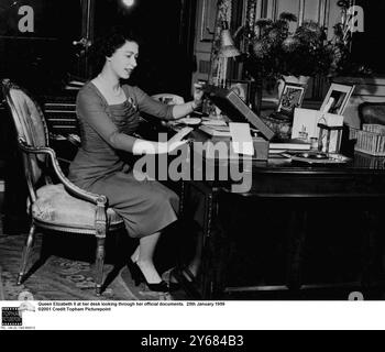 La regina Elizabeth ll alla sua scrivania che guarda i suoi documenti ufficiali. 25 gennaio 1959 Foto Stock