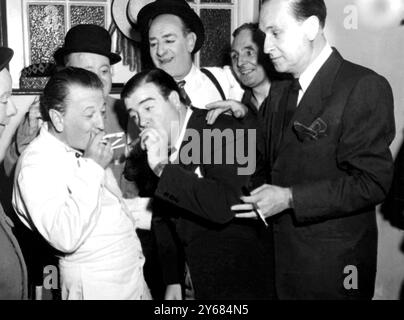 I folli comici americani, Bud Abbott e Lou Costello, che sono qui per giocare al Palladium, oggi hanno visitato il Victoria Palace e incontrato The Crazy Gang, Bud Flanagan, Nervo e Knox, e Naughton e Gold. Spettacoli fotografici: Jimmy Nervo, un po' stravagante con le sigarette, prende una luce dal sigaro di Lou Costello al Victoria Palace oggi. Da sinistra a destra: Harry Gold, Nervo, Naughton (dietro), Lou Costello, Bud Flanagan, Teddy Knox e Bud Abbott. 19 luglio 1950 Foto Stock