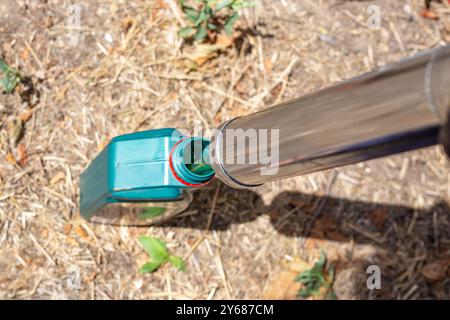 Cambio dell'olio nelle unità di trasmissione. Il meccanico aspira l'olio da un contenitore utilizzando una siringa di olio. Foto Stock