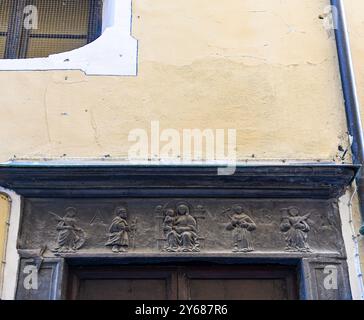 Portale in ardesia della Chiesa della Carità (XIV sec) con bassorilievo raffigurante la Madonna in trono con bambino circondata da santi, Alassio, Liguria Foto Stock