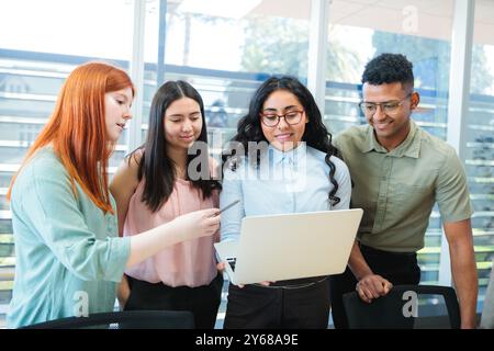 Lavoro di squadra multirazziale che collabora alle strategie aziendali, in piedi intorno a un tavolo e facendo brainstorming in un ufficio moderno Foto Stock