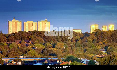 Glasgow, Scozia, Regno Unito. 24 settembre 2024. Meteo nel Regno Unito: Luce rossa del tramonto sulla città. L'estremità occidentale della città con il colore autunnale del parco dawsholm e le torri del consiglio di maryhill sullo sfondo. Credit Gerard Ferry/Alamy Live News Foto Stock