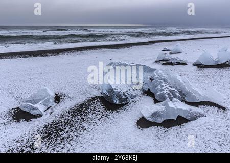 Piste di ghiaccio sulla spiaggia, innevate, onde, mare, nuvole, Winter, Diamond Beach, Breidamerkursandur, Joekulsarlon, Islanda, Europa Foto Stock