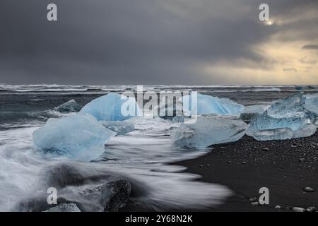 Banchi di ghiaccio sulla spiaggia, onde, mare, nuvole, luce del sole, Winter, Diamond Beach, Breidamerkursandur, Joekulsarlon, Islanda, Europa Foto Stock