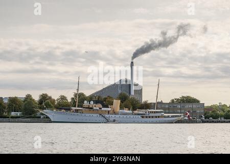 Lo yacht reale danese o lo yacht Dannebrog, nell'impianto di incenerimento dei rifiuti di sfondo CopenHill o Amager Bakke con pista da sci e seggiovia sul roo Foto Stock