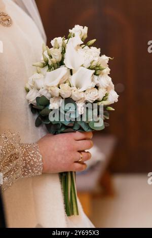 Elegante bouquet nuziale di gigli e rose bianche di Calla con verdi all'eucalipto. Foto Stock